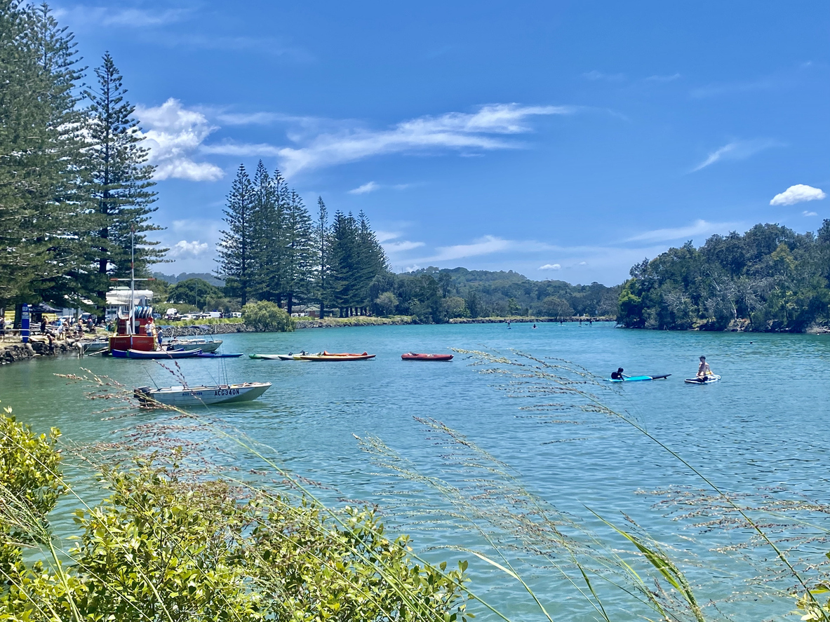 The Brunswick River at Brunswick Heads on a clear day, kayaks and paddleboards on turquoise water