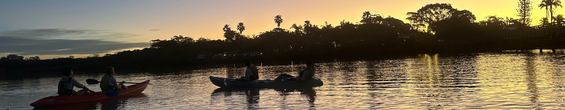 Paddlers in kayaks watching the sunset on the Brunswick River